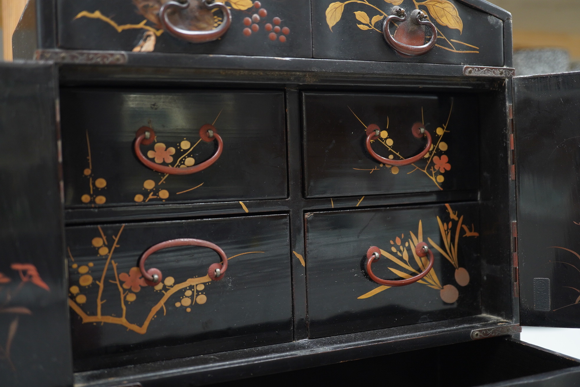 A late 19th early 20th century Japanese lacquer cabinet, 31cm high. Condition - exterior chipped and cracked near the top edge